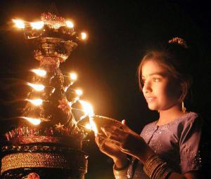 INDIAN GIRL LIGHTS A DEEPAWALI LAMP IN AHMEDABAD